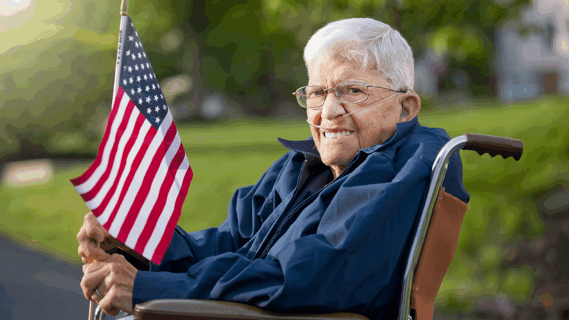 Senior disabled veteran on a wheelchair carrying US flag