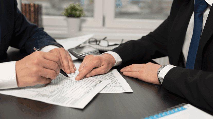 Tax adviser guiding client in filling out tax forms