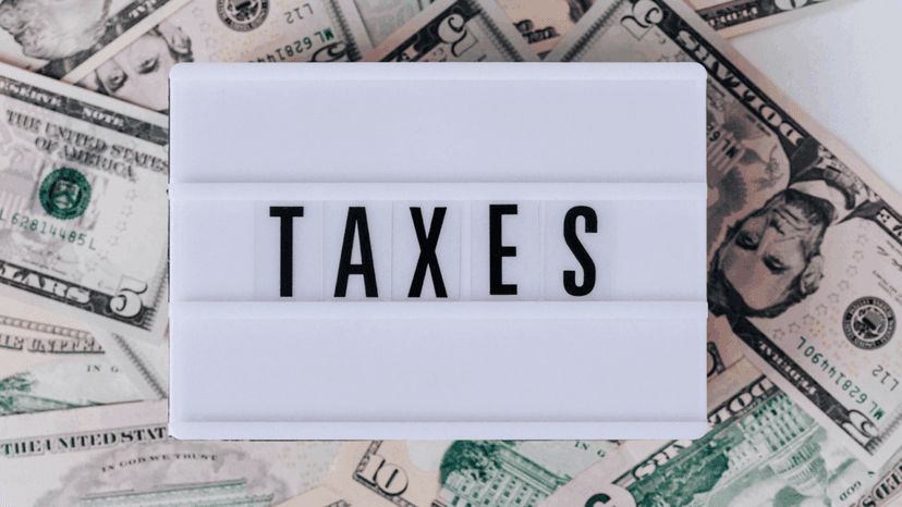 Taxes word on quote box on top of stack of paper bills