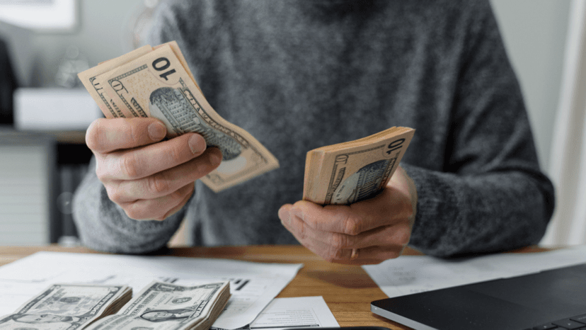 A homeowner counting cash refund from an escrow account surplus