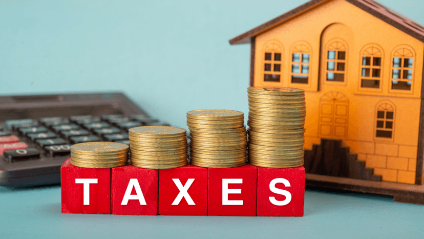 Property Tax Concept With Coins and House Model on Table