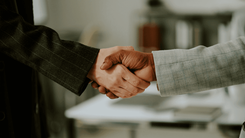 Two professionals closing a real estate deal with a handshake