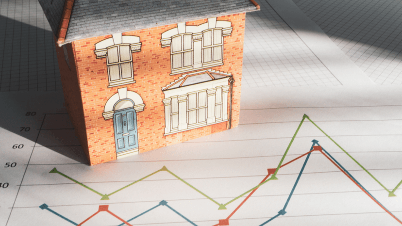 A house model placed on a chart showing rising property market trends