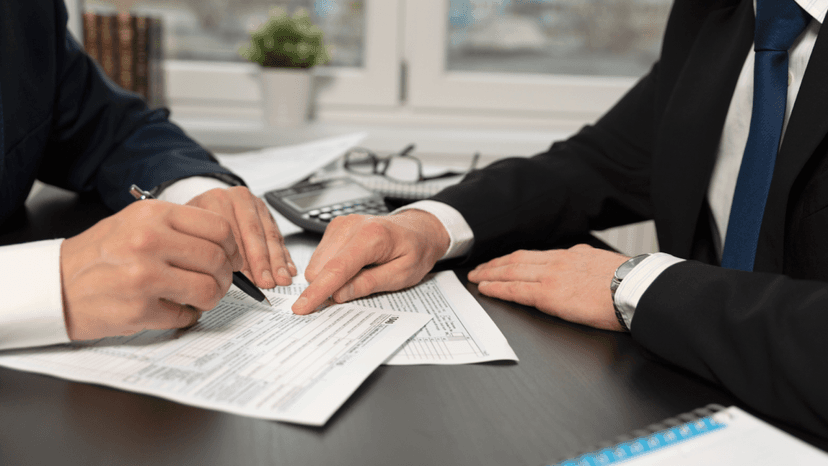 A property owner signing documents with a consultant to protest tax valuation