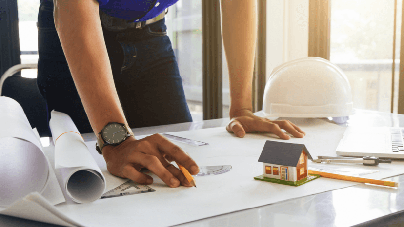 Construction professional reviewing blueprints before repurposing Houston property