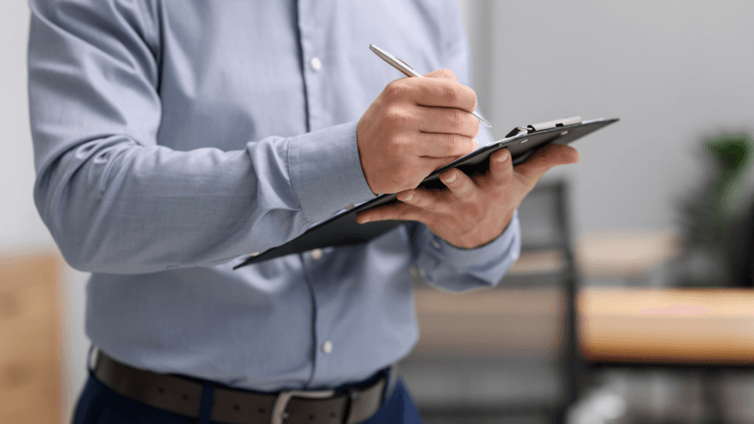 A professional appraiser writing notes during a commercial property assessment
