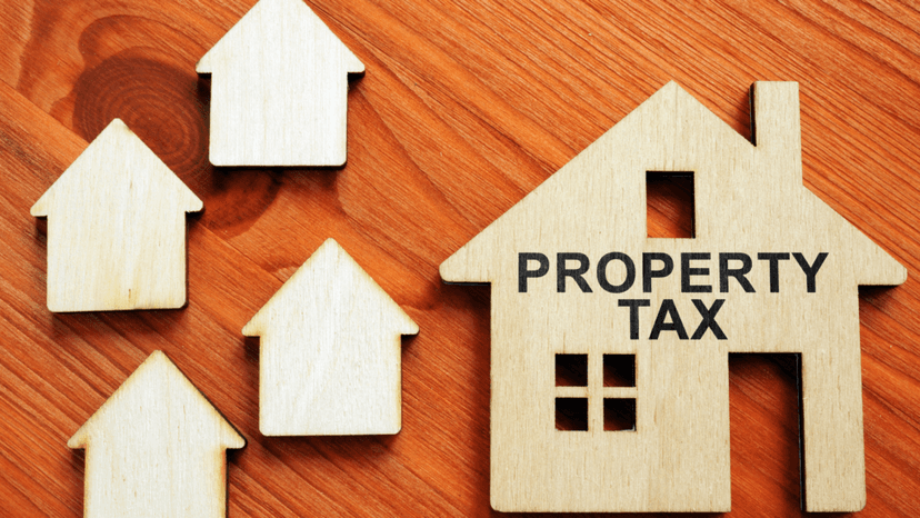 Wooden house cutouts with property tax label representing rising Texas assessments