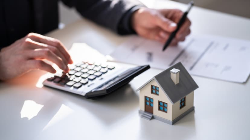 Reviewing tax rate paperwork with a calculator and house model